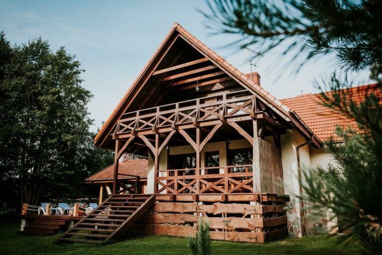 Gustaw-Mazury - Widok na dom i taras od strony jeziora, huśtawki i wiaty z grillem